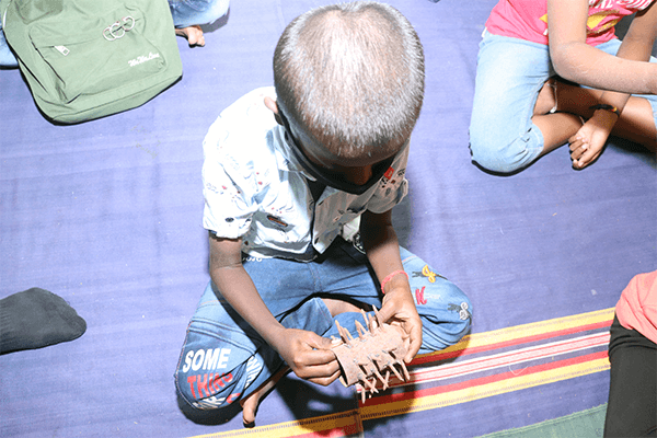 Student looks at a torture device called a “yoke spike” that was confiscated by Animal Rahat.