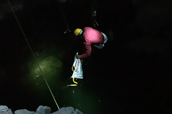 A rescue worker for Animal Rahat manages to secure the snakes inside a bag and have them pulled to safety.