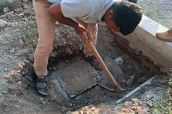 An Animal Rahat rescue worker uses a pickax to break open the sealed chamber.