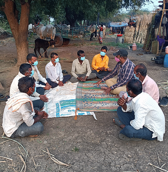 Meeting attendees listen attentively as an Animal Rahat staff member talks to them about proper healthcare for bullocks, such as regular hoof maintenance and removing nose ropes.