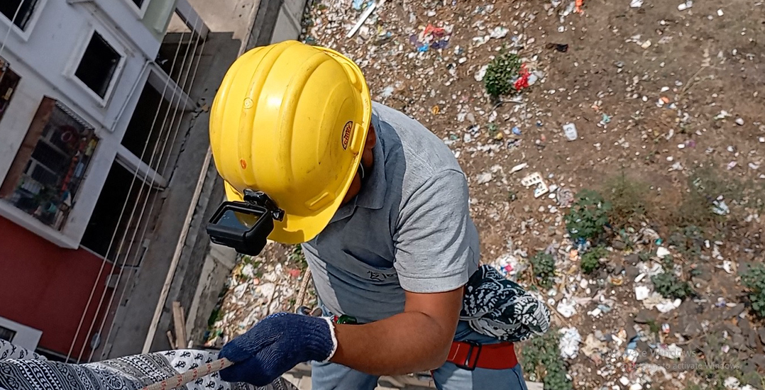 An Animal Rahat worker rappels down a five-story building.